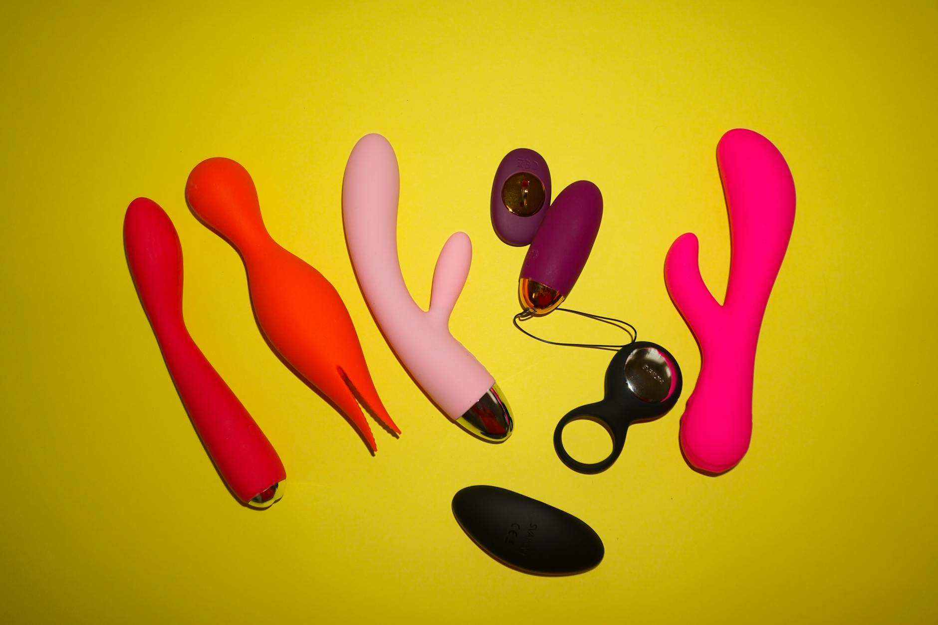 Colorful vibrators on bright yellow background, including lemon-shaped designs